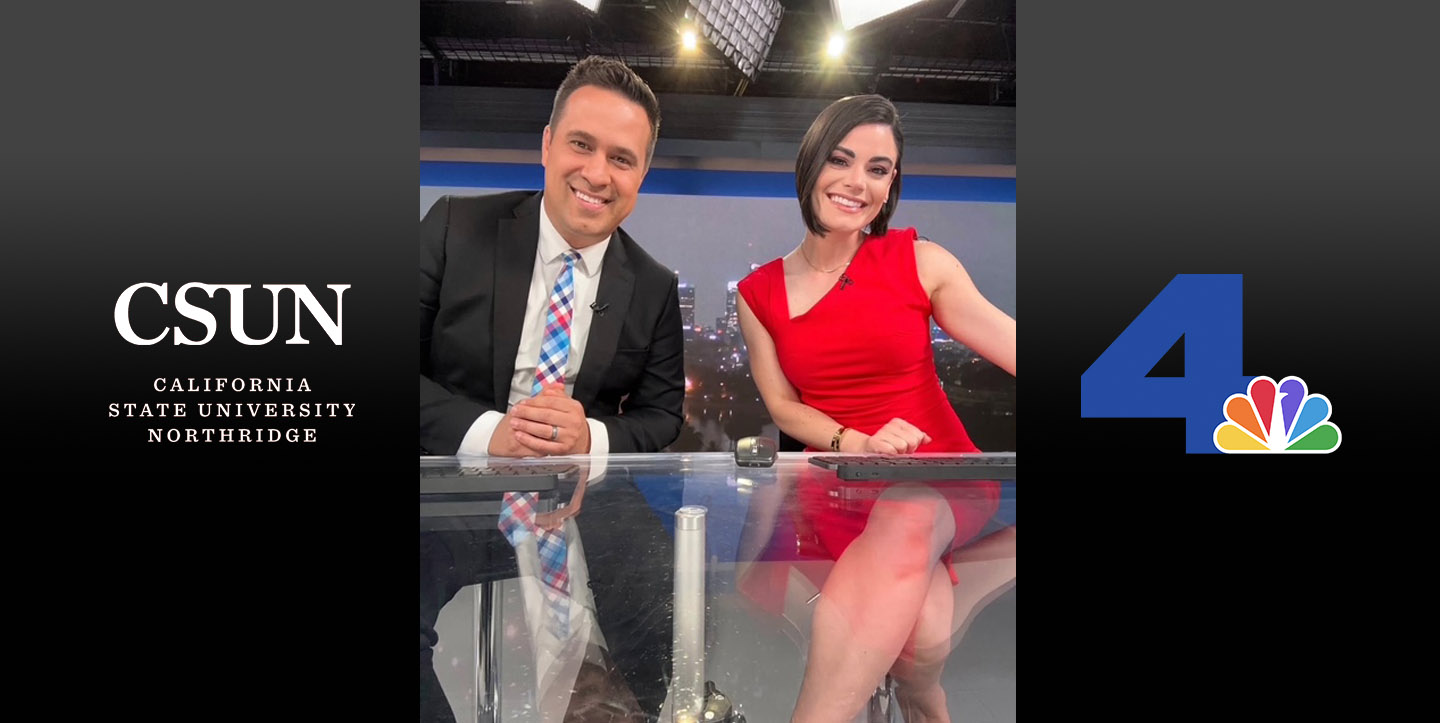 Two news anchors seated at a news desk.